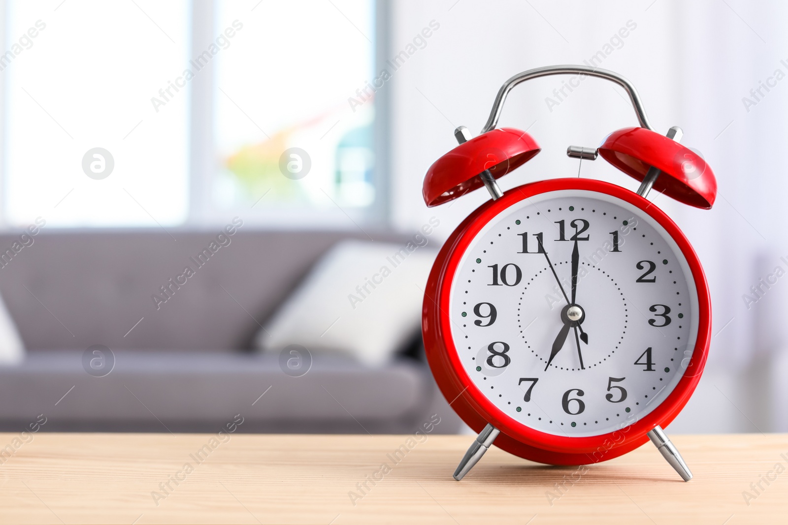 Photo of Alarm clock on table in living room. Time of day