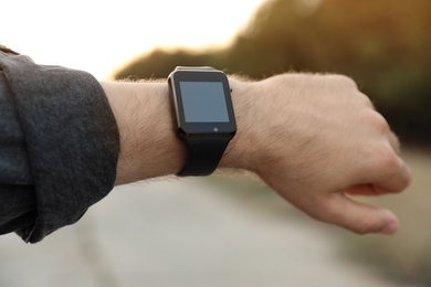 Photo of Man with smart watch outdoors, closeup view