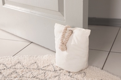 Photo of Stuffed bag holding wooden door at home