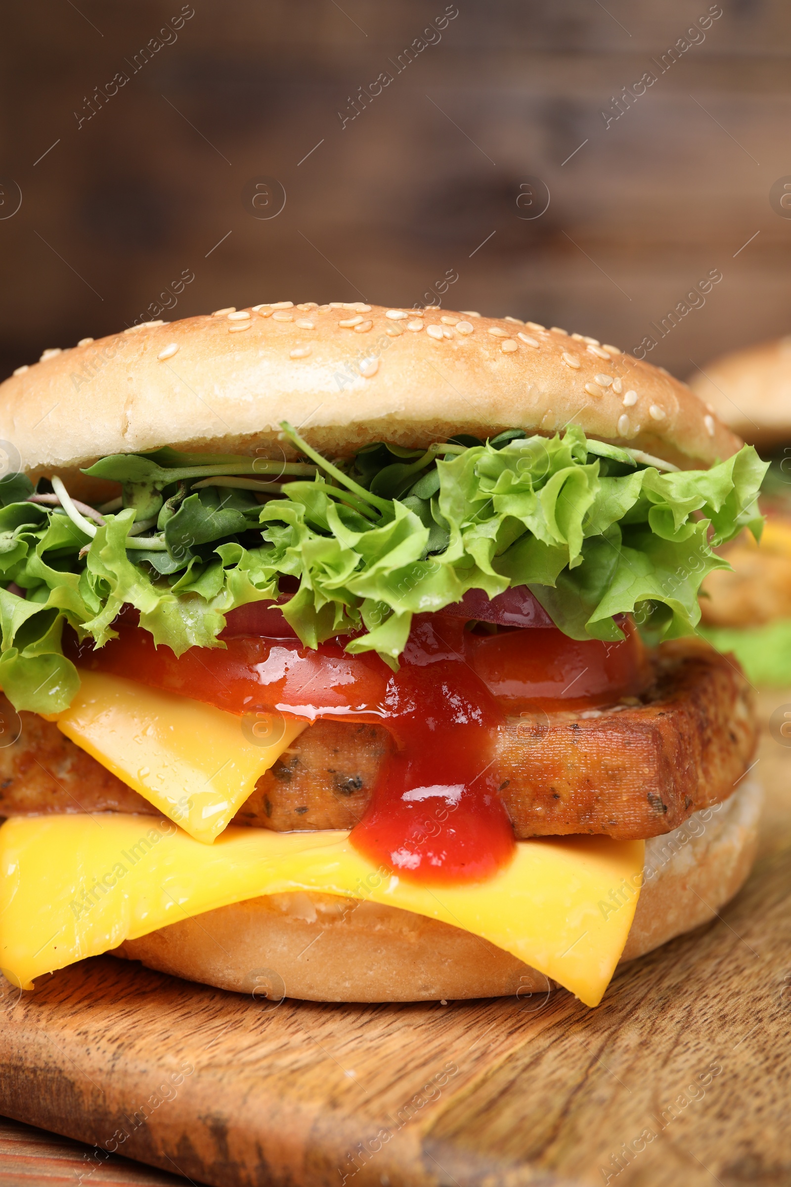 Photo of Delicious burger with tofu, fresh vegetables and sauce on wooden board, closeup