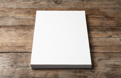 Photo of Stack of blank paper sheets for brochure on wooden background. Mock up