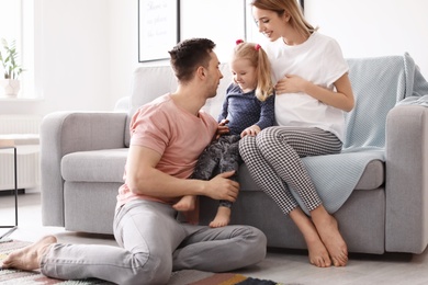 Young pregnant woman with her family at home