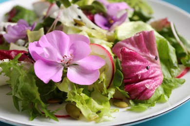 Photo of Fresh spring salad with flowers on plate, closeup