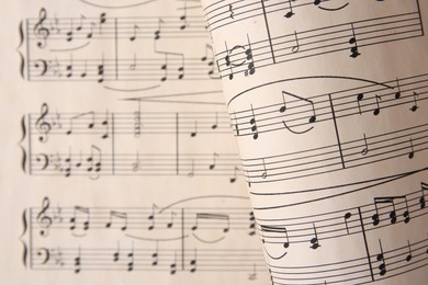 Photo of Sheets with music notes as background, top view. Space for text