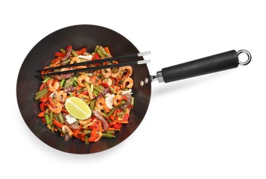 Photo of Shrimp stir fry with vegetables in wok and chopsticks isolated on white, top view