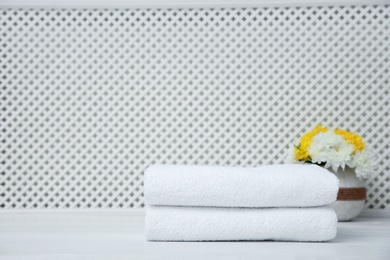 Photo of Stack of towels on table against light background