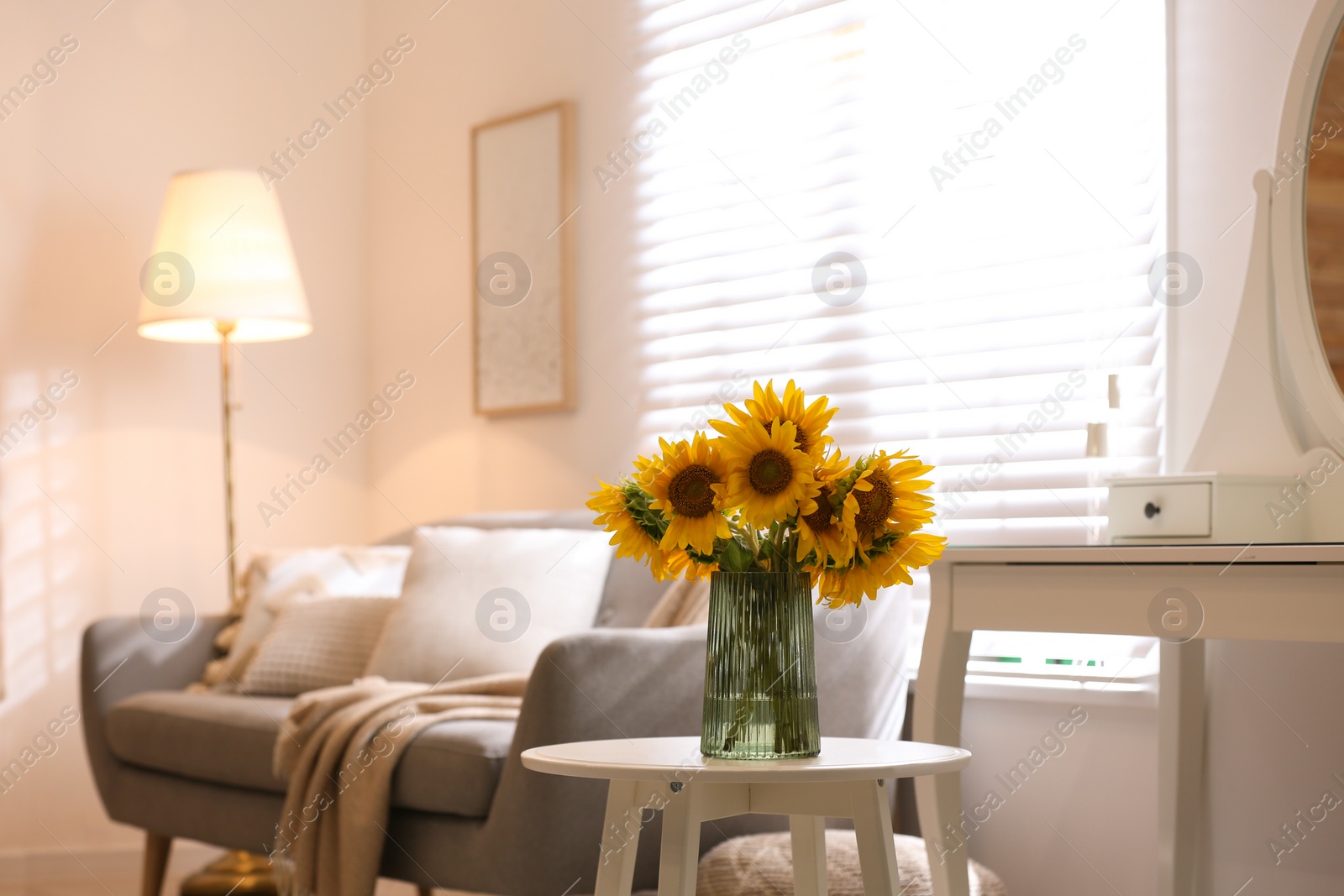 Photo of Beautiful bouquet of sunflowers in vase on white table indoors. Space for text