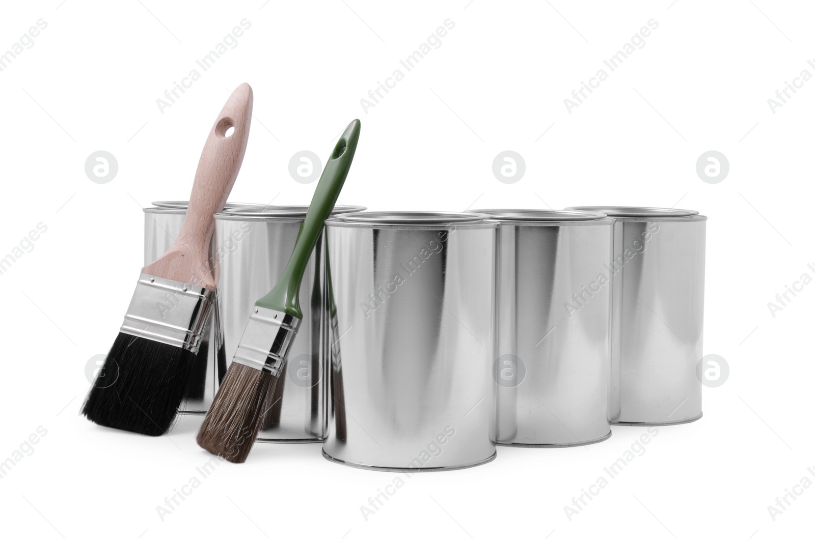 Photo of Cans of paints and brushes on white background