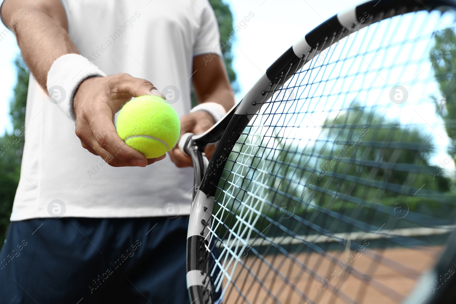 Photo of Sportsman preparing to serve tennis ball at court, closeup