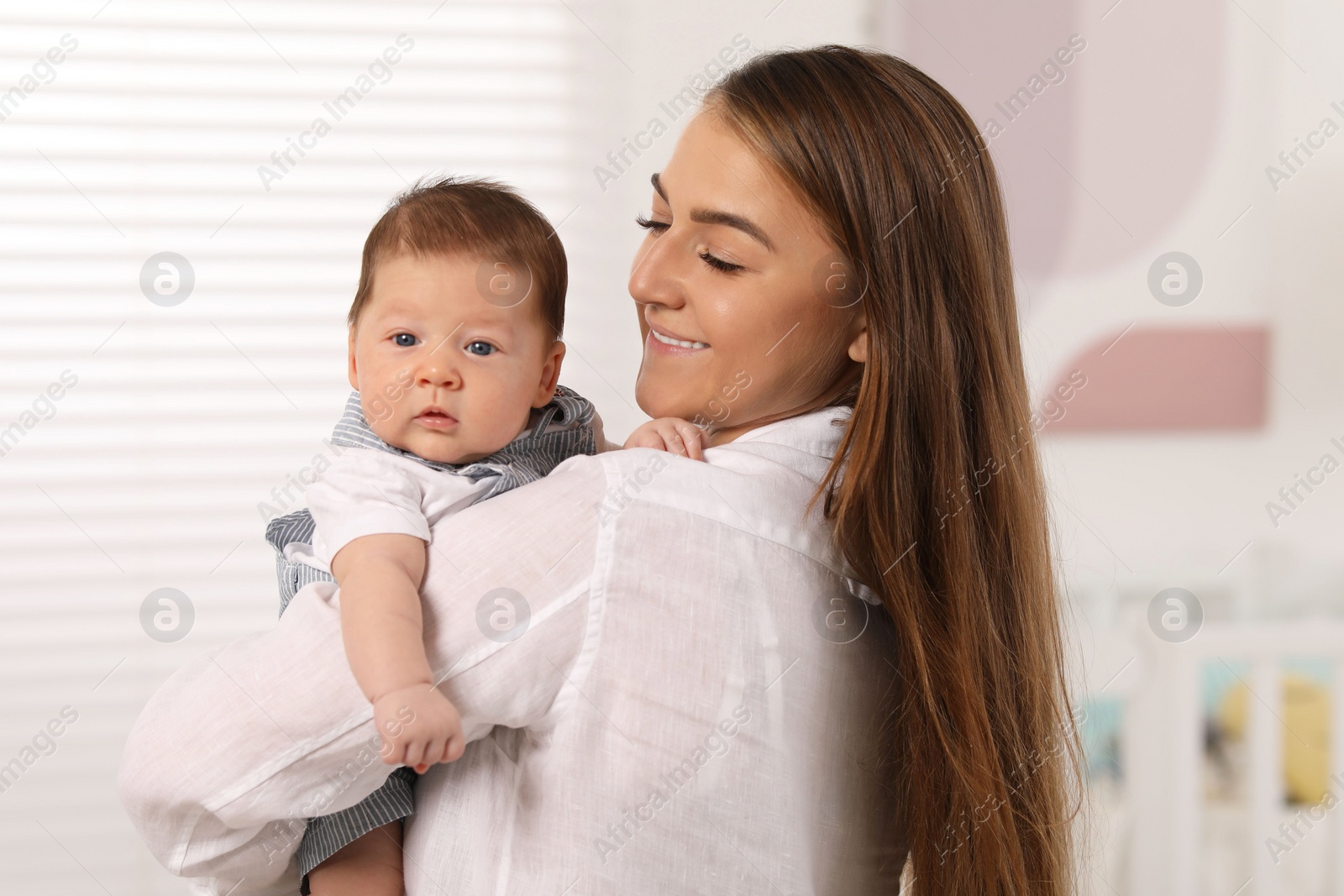 Photo of Mother holding her cute newborn baby at home