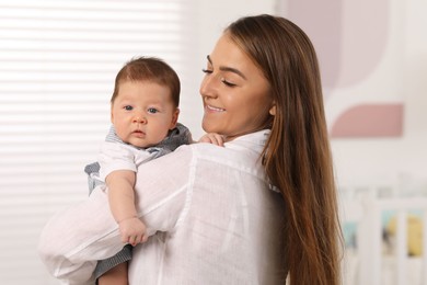 Mother holding her cute newborn baby at home