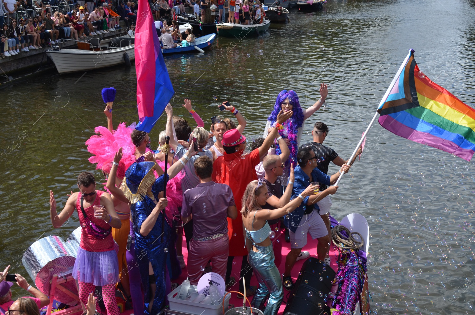 Photo of AMSTERDAM, NETHERLANDS - AUGUST 06, 2022: Many people in boats at LGBT pride parade on river