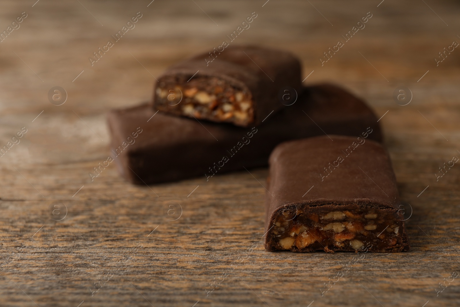 Photo of Tasty protein bars on wooden table. Space for text