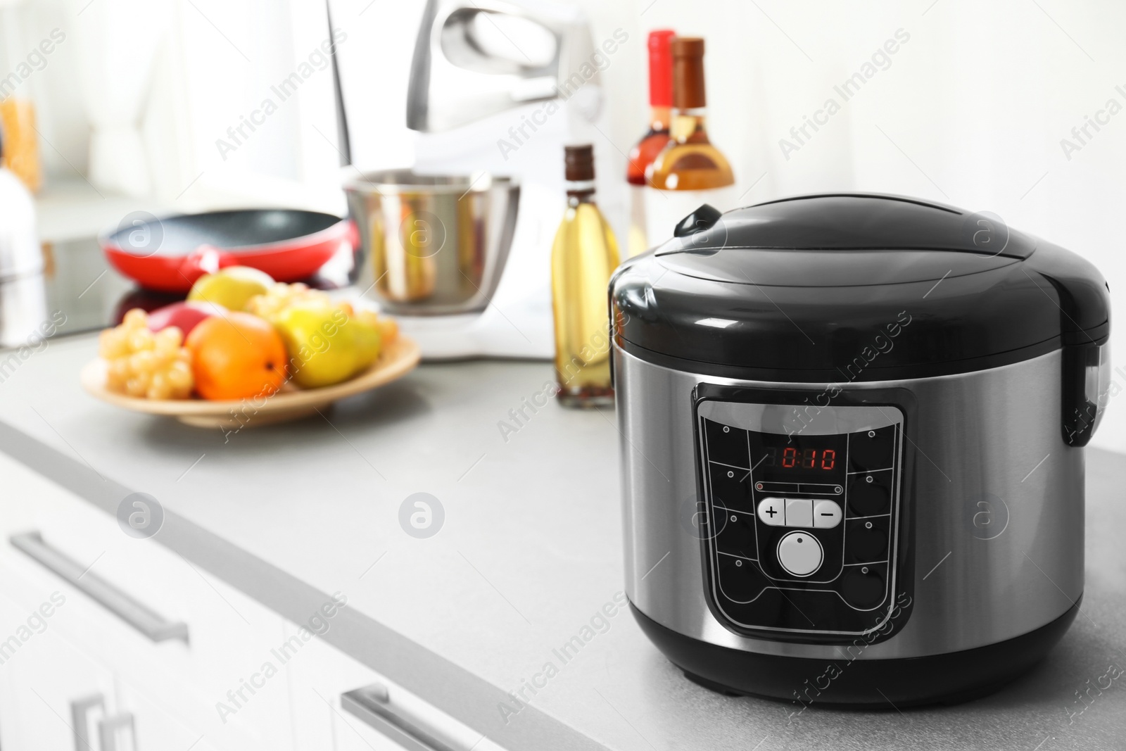 Photo of Modern multi cooker and products on table in kitchen. Space for text