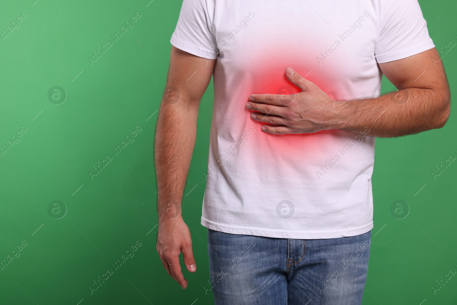 Image of Man suffering from stomach pain on green background, closeup