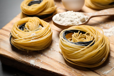 Raw linguine pasta on wooden board, closeup