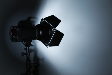 Professional photo studio lighting equipment on dark background. Space for text