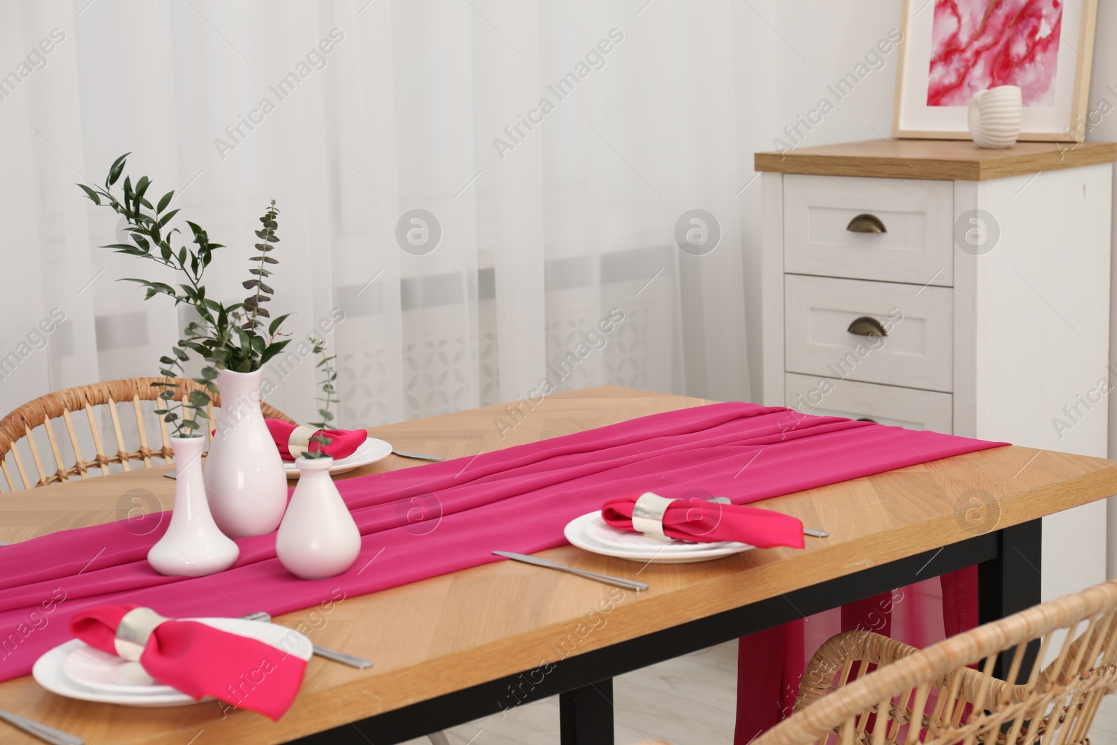 Photo of Beautiful table setting and vases with green branches in dining room