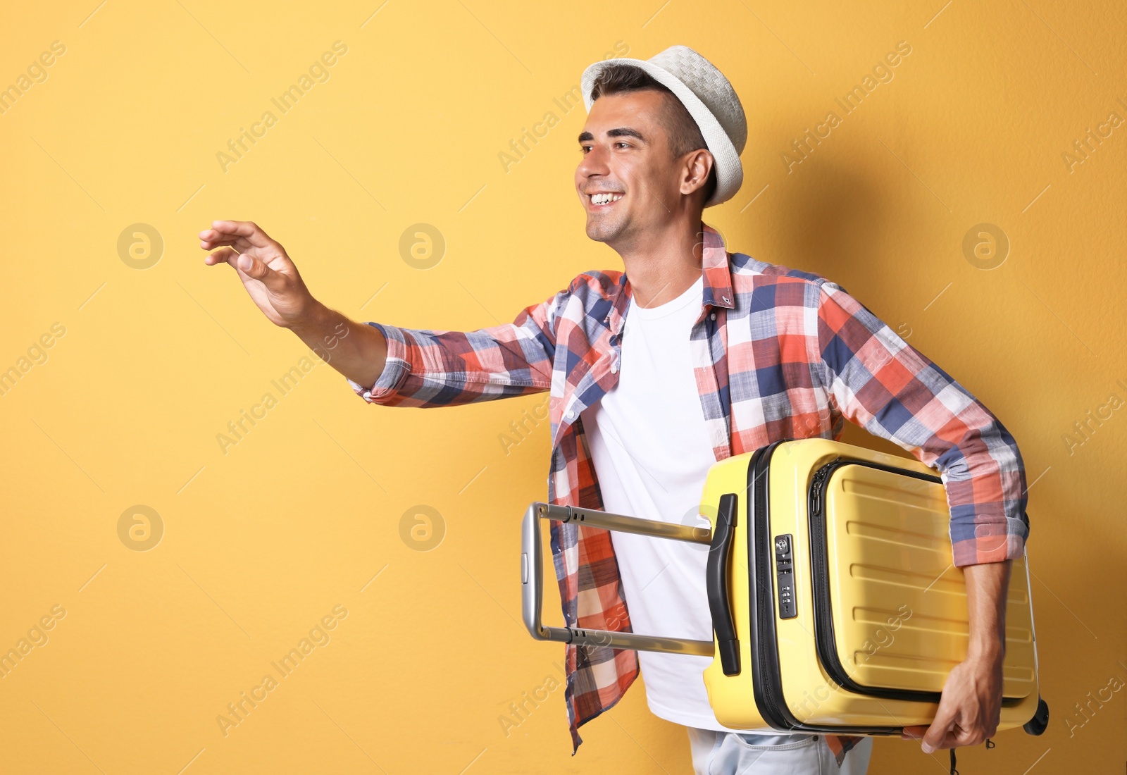 Photo of Young man with suitcase on color background