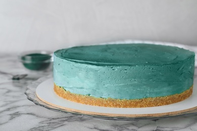 Photo of Delicious homemade spirulina cheesecake on marble table