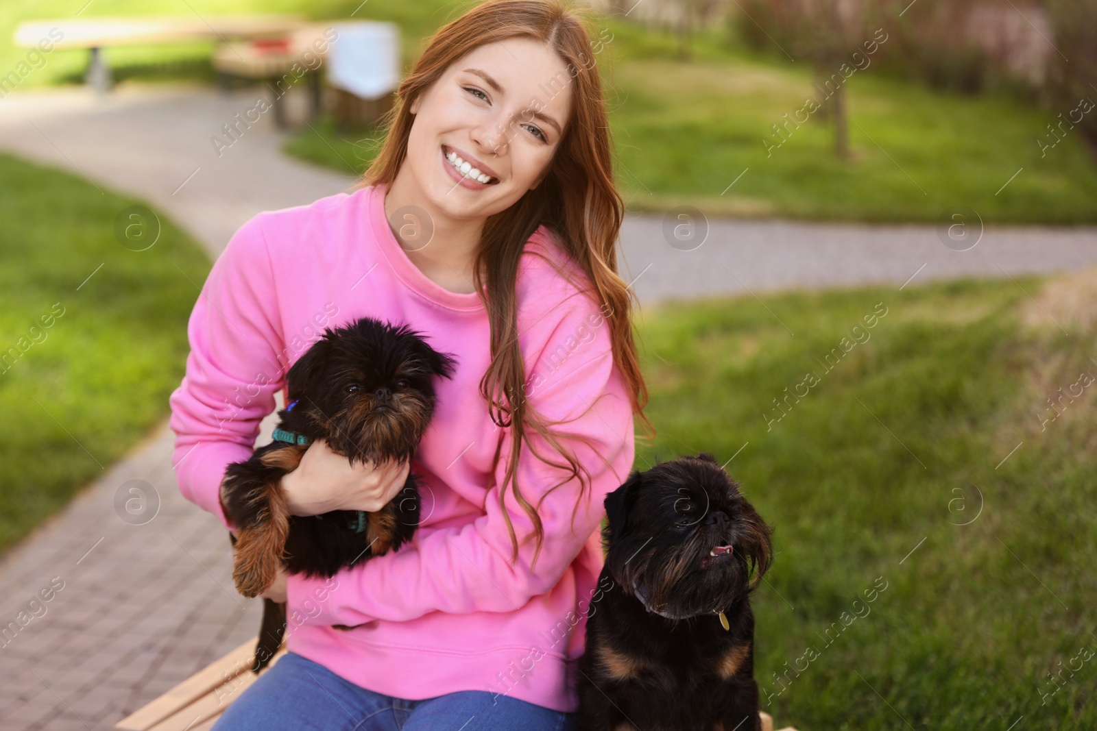 Photo of Young woman with adorable Brussels Griffon dogs outdoors