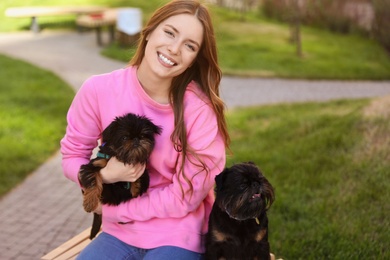 Photo of Young woman with adorable Brussels Griffon dogs outdoors