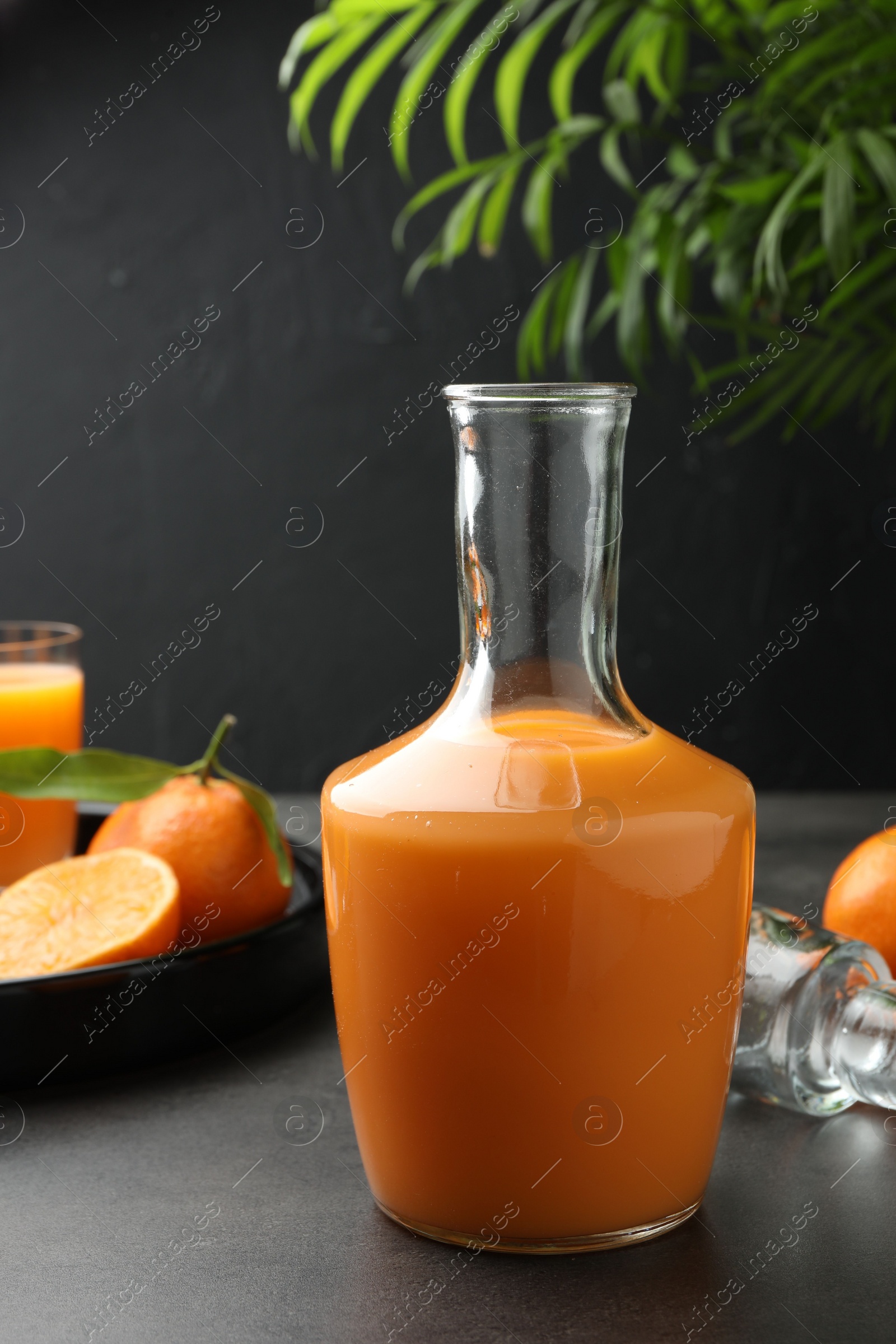 Photo of Delicious tangerine liqueur and fresh fruits on grey table