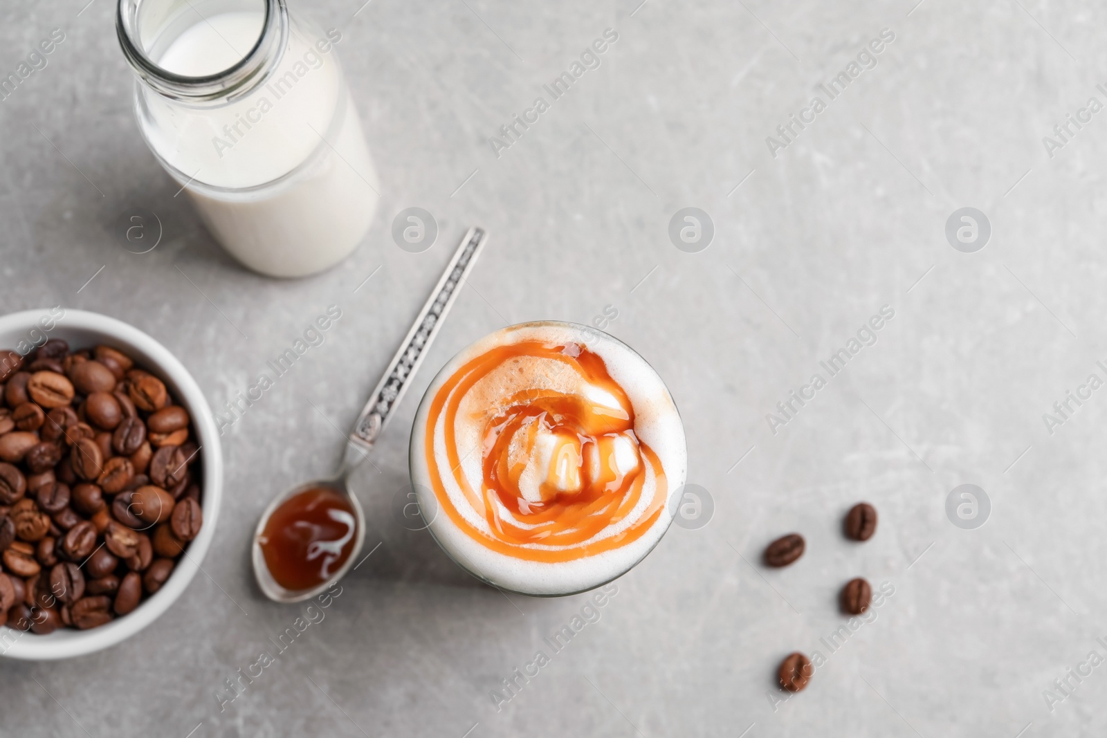 Photo of Glass with delicious caramel latte on table