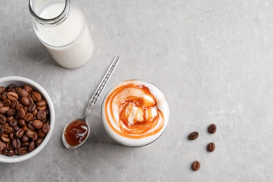 Photo of Glass with delicious caramel latte on table