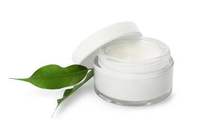 Face cream in glass jar and leaves on white background
