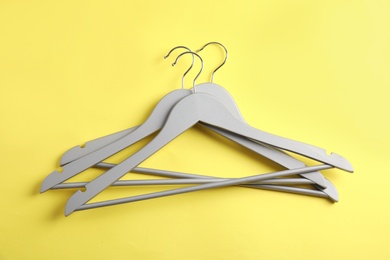 Photo of Empty clothes hangers on color background, top view