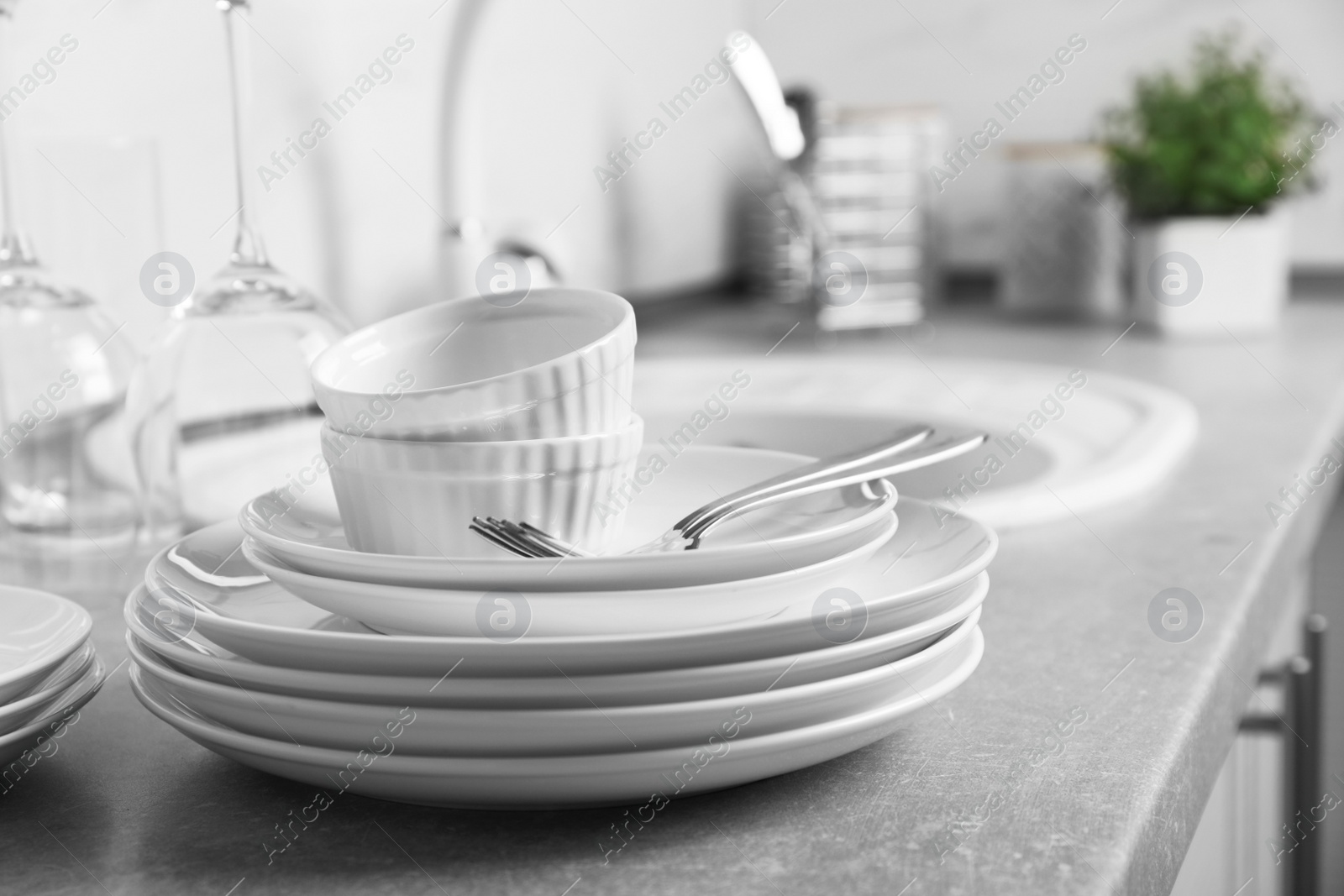 Photo of Set of clean dishes and cutlery on kitchen counter