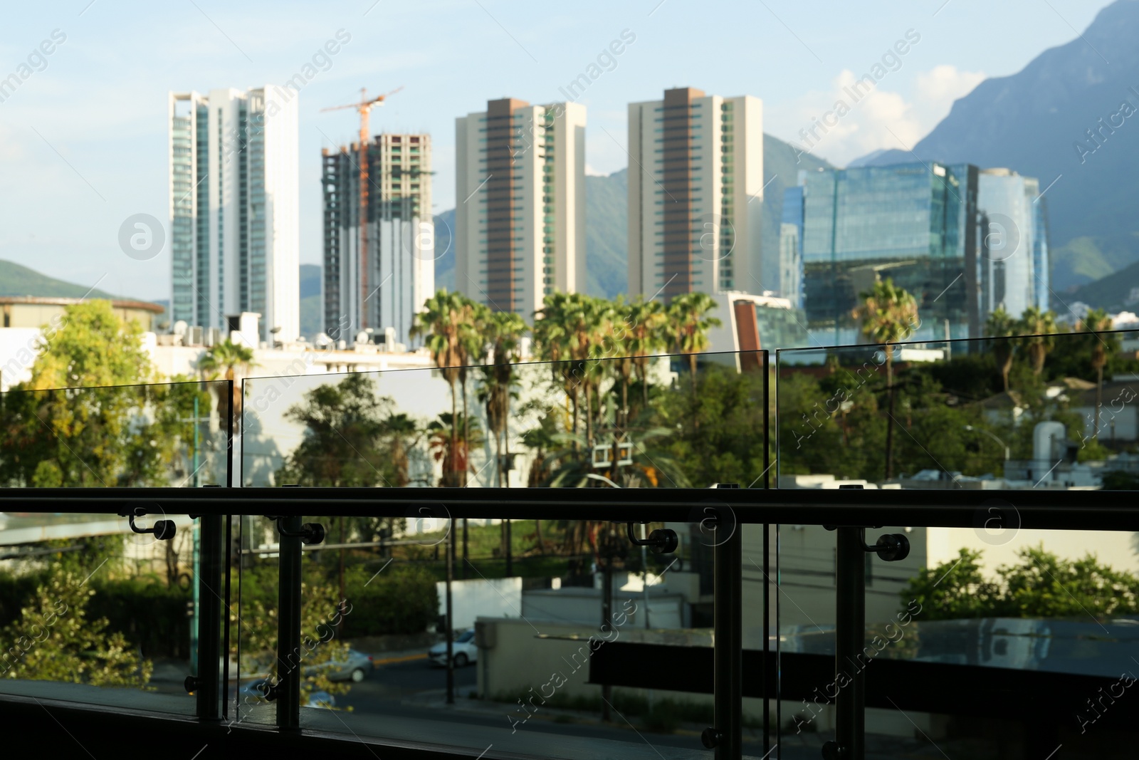 Photo of View of city behind balcony with metal handrails