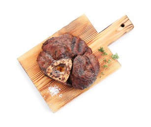 Photo of Piece of delicious grilled beef meat, thyme and salt isolated on white, top view
