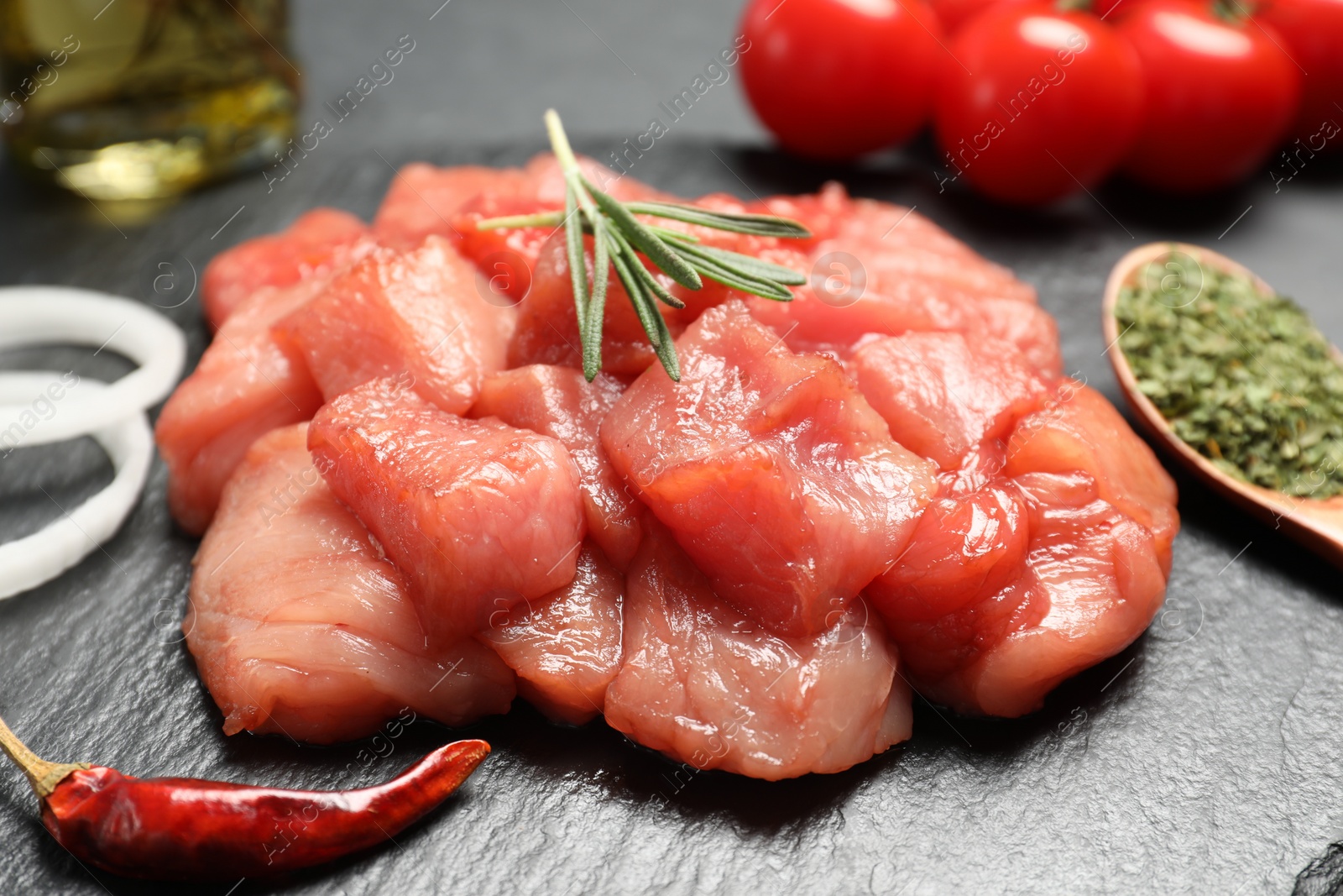 Photo of Cooking delicious goulash. Raw beef meat on slate board, closeup