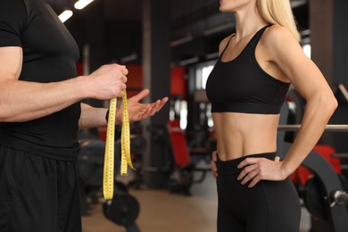 Photo of Trainer having discussion with woman in gym, closeup