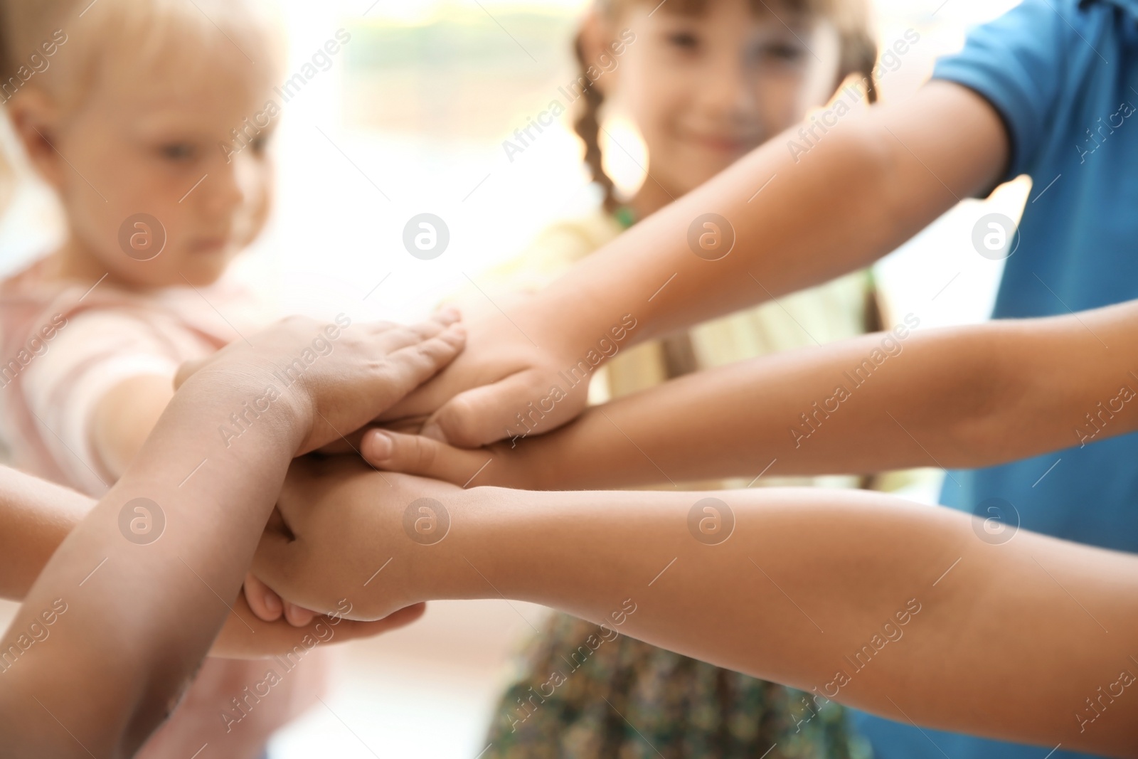 Photo of Little children putting their hands together, closeup. Unity concept