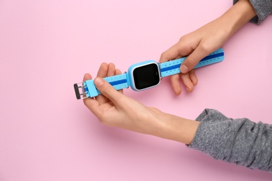 Photo of Boy with stylish smart watch on pink background, top view