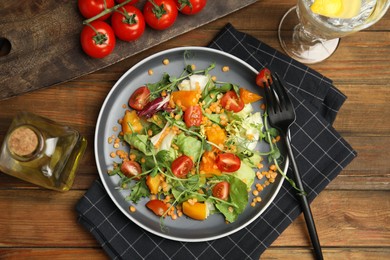 Photo of Delicious salad with lentils and vegetables served on wooden table, flat lay