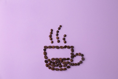 Cup made of coffee beans on lilac background, flat lay