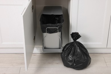 Photo of Plastic garbage bag and trash can indoors