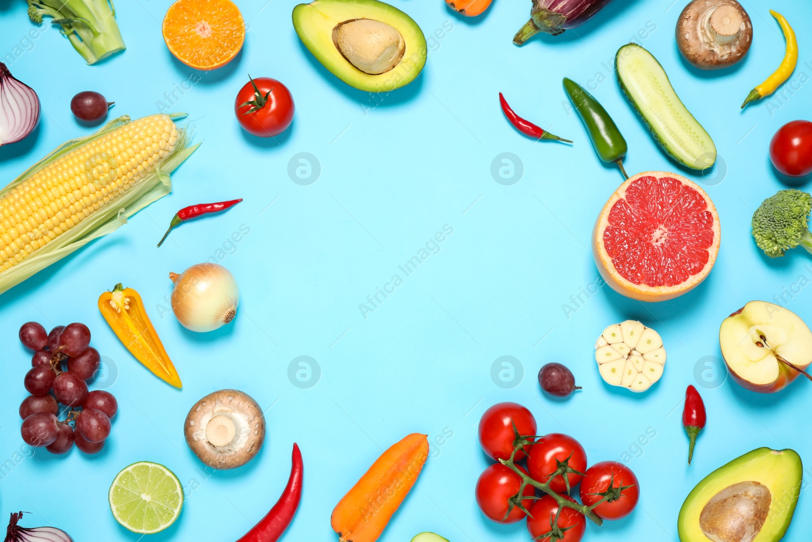 Photo of Frame of fresh organic fruits and vegetables on light blue background. Space for text