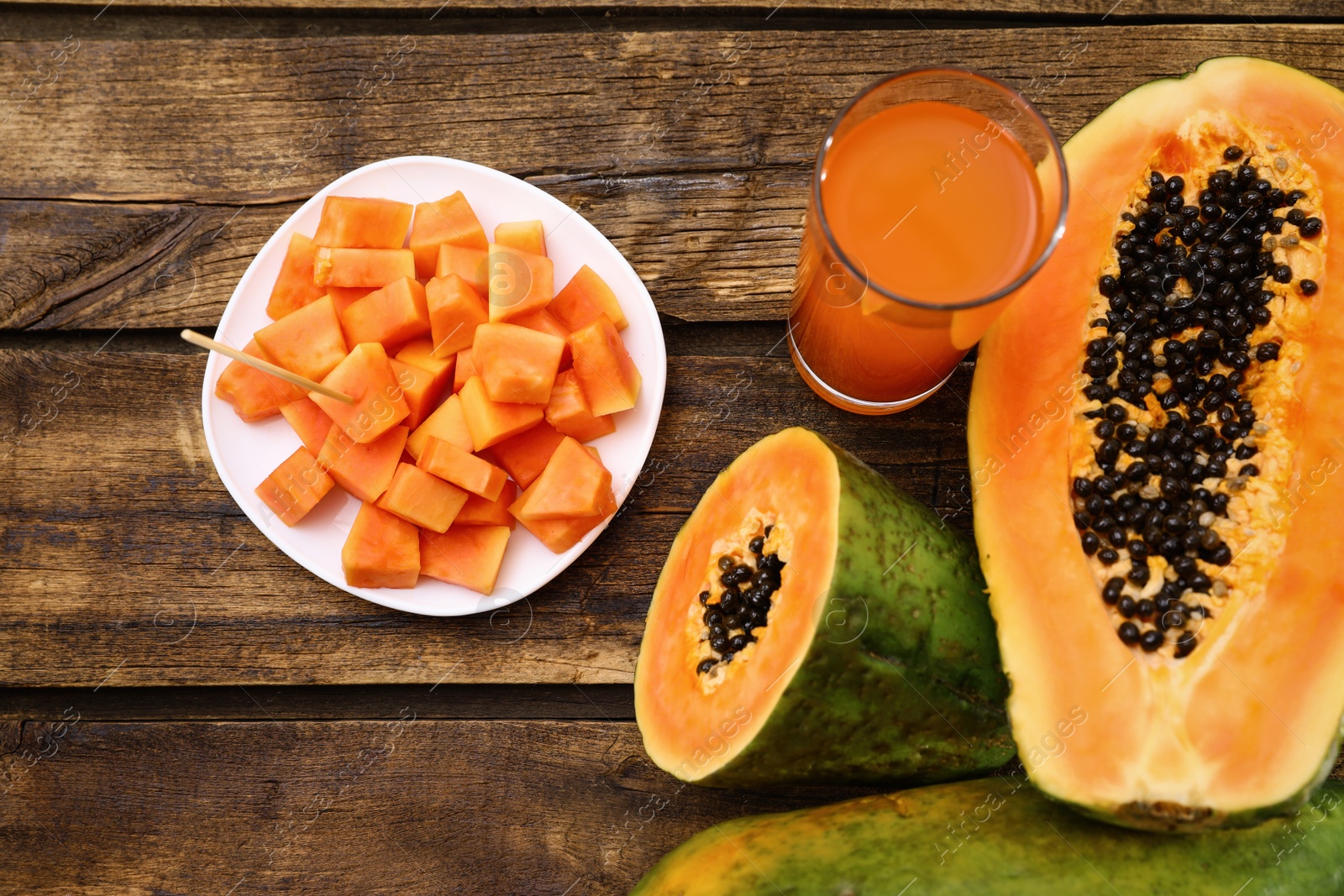 Photo of Flat lay composition with fresh papayas and juice on wooden table