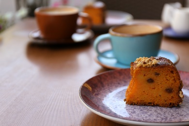 Photo of Plate with slice of carrot cake on wooden table