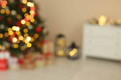 Beautiful tree decorated for Christmas and gift boxes indoors, blurred view. Interior design