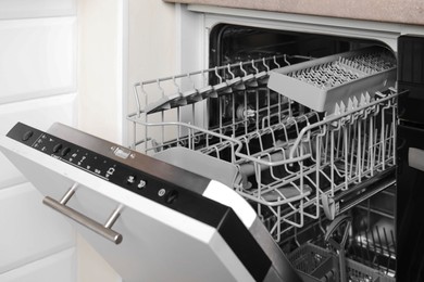 Open clean empty dishwasher in kitchen. Home appliance