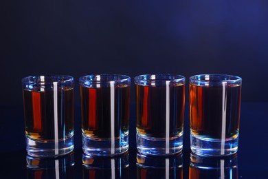 Photo of Alcohol drink in shot glasses on mirror surface