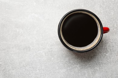 Photo of Cup of aromatic coffee on light grey table, top view. Space for text
