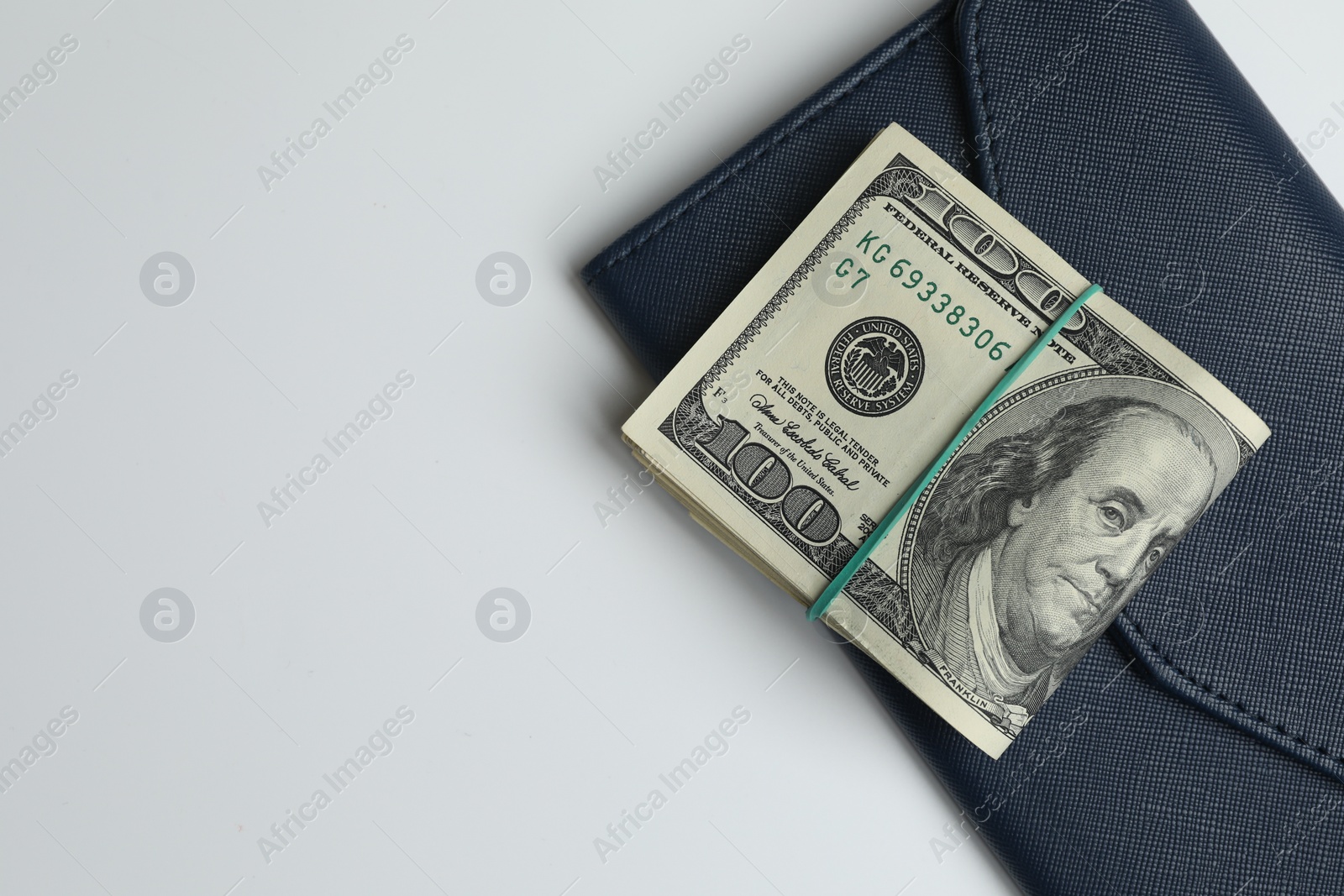 Photo of Money exchange. Dollar banknotes and wallet on white background, top view. Space for text