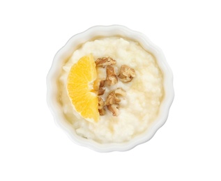 Photo of Creamy rice pudding with orange slice and walnuts in ramekin on white background, top view